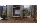 Rustic weathered exterior featuring a window with a wooden seat and small balcony at 5796 Par Four Ct, Lithonia, GA 30038