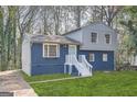Charming two-story home featuring a blue exterior, brick foundation, and a well-maintained green lawn at 6192 Holiday Blvd, Forest Park, GA 30297