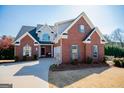 Beautiful two-story brick home boasts a pristine lawn, covered entrance, attached garage and well-maintained landscaping at 106 Victoria Way, Carrollton, GA 30116