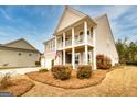 Charming home with a double-decker porch, lush landscaping, and a side-entry garage at 305 Roundwood Way, Peachtree City, GA 30269