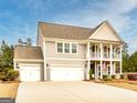 Beautiful two-story home featuring a welcoming porch and an attached three-car garage at 305 Roundwood Way, Peachtree City, GA 30269