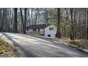 Exterior of home displaying long driveway leading to the house with a welcoming front deck and wooded surroundings at 3189 Fern Ridge Ne Dr, Conyers, GA 30013