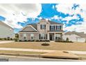 Two story home with brick and stone, black shutters, covered porch, and well-maintained lawn at 814 Parker Pass, Peachtree City, GA 30269