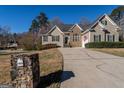 Attractive home with stone and siding exterior, a well-kept lawn, and a long driveway leading to a two-car garage at 1491 Hada Ln, Lawrenceville, GA 30044