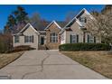 Beautiful home with a combination of stone and siding, complemented by lush greenery and blossoming trees at 1491 Hada Ln, Lawrenceville, GA 30044
