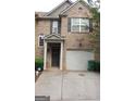 Charming two-story brick townhome featuring a one-car garage and a welcoming covered front entry at 2742 Keystone Gates Ct, Lithonia, GA 30058
