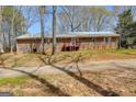 Image showing the back of this brick home with a door with red trim and a small deck with red trim at 327 Old Muse Rd, Carrollton, GA 30116