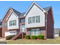 Attractive two-story home featuring brick and gray siding, green shutters, and a landscaped front yard at 1100 Parkside Ln, Mcdonough, GA 30253
