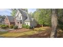 Home exterior with gray siding, brick, and a spacious lawn in a wooded neighborhood at 255 Squire Ln, Fayetteville, GA 30214