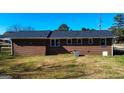 Rear exterior view of a brick home with well-maintained lawn and some trees at 6268 Mount Zion Blvd, Morrow, GA 30260