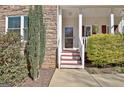 Inviting front porch with stone accents and well-maintained landscaping at 55 Sturgess Run, Sharpsburg, GA 30277