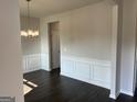 Classic dining room with dark wood floors, white wainscoting, and decorative chandelier at 4130 Chapel Hill Reserve, Douglasville, GA 30135