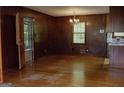 Dining room featuring hardwood floors, wood paneling, and vintage chandelier at 2102 Mulkey Sw Rd, Marietta, GA 30008