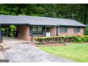 A brick ranch home featuring a covered carport and a neatly kept front yard at 2102 Mulkey Sw Rd, Marietta, GA 30008