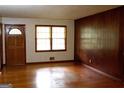 Living room with hardwood floors, wood paneling, and a window providing natural light at 2102 Mulkey Sw Rd, Marietta, GA 30008