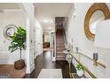 Elegant foyer features hardwood floors, a staircase, and a decorative mirror over an accent table at 3863 Rosebay Way, Conyers, GA 30094