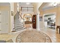Bright foyer with staircase, decorative rug, and views into the living room and kitchen at 211 Collierstown Way, Peachtree City, GA 30269