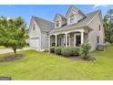 Charming home featuring a stone facade, white pillars, tidy bushes, and a well manicured lawn at 211 Collierstown Way, Peachtree City, GA 30269