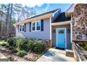 Close-up of a home's entrance showcasing the blue door, stone accents, and tidy landscaping at 2304 Larchmont Ct, Villa Rica, GA 30180