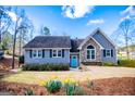 Charming home with stone accents, blue front door, and blossoming spring flowers in the front yard at 2304 Larchmont Ct, Villa Rica, GA 30180