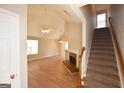 Open-concept living room featuring hardwood floors, fireplace, and staircase at 626 N Fairfield Dr, Peachtree City, GA 30269