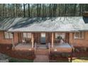 Inviting home with a welcoming front porch, complete with rocking chairs, swing and brick detailing at 222 Providence Rd, Fayetteville, GA 30215