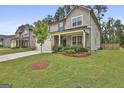 Charming home with well-manicured lawn, covered porch, and a young tree in the front yard at 734 Lanarck Way, Peachtree City, GA 30269