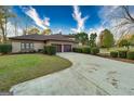Spacious home with a long, curved driveway leading to a three-car garage surrounded by lush landscaping at 2279 Fieldstone Dr, Conyers, GA 30013