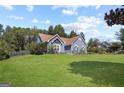 Beautiful exterior showcasing a blue stucco house on a vast green lawn, surrounded by trees at 131 Pecan Lake Dr, Sharpsburg, GA 30277