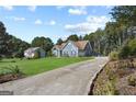 Spacious home with a long driveway and expansive front yard, surrounded by mature trees at 131 Pecan Lake Dr, Sharpsburg, GA 30277