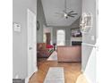 Inviting living room with herringbone floors, a ceiling fan, and an elegant stone fireplace at 131 Pecan Lake Dr, Sharpsburg, GA 30277