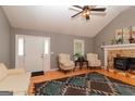 Cozy living room featuring a stone fireplace, hardwood floors, vaulted ceiling, and abundant natural light at 11555 Brown Bridge Rd, Covington, GA 30016