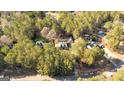 Aerial view showcases this beautiful property nestled among dense trees with a view of other houses and roadways at 406 Tapley Rd, Villa Rica, GA 30180