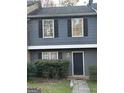 Two-story townhome featuring a gray exterior, black shutters, and a neatly landscaped front entrance at 8547 Jamestown Way, Jonesboro, GA 30238
