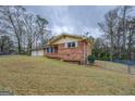 Brick home with a two-car garage and a satellite dish on the roof, surrounded by a grassy yard and mature trees at 9138 Parnell Sw St, Covington, GA 30014