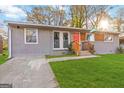 The inviting home has an orange door, gray siding, and a bright green lawn at 1894 Evans Evans Sw Dr, Atlanta, GA 30310