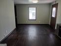 Living room with hardwood floors, neutral green walls, single window, and an exterior door at 5549 Highway 42, Ellenwood, GA 30294