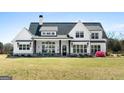 Charming two-story home boasts black accents, a welcoming front porch, and verdant green lawn at 105 Coogler Way, Brooks, GA 30205