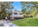 Split-level home showing a large driveway and well-kept lawn with mature trees at 1343 Burbank Trl, Morrow, GA 30260