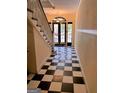 Inviting foyer features a checkered floor, grand staircase, and a doorway leading to the outside at 242 12Th St Ne 1 1A, Atlanta, GA 30309