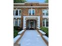 Charming red brick apartment building with white trim, a walkway, and well-maintained landscaping at 242 12Th St Ne 1 1A, Atlanta, GA 30309