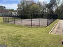 Outdoor tennis court surrounded by a chain-link fence, offering a recreational amenity for residents at 122 Lake Ter, Mcdonough, GA 30253