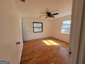 Bright bedroom with hardwood floors, ceiling fan, and plenty of natural light from two windows at 1433 Butler St, Jonesboro, GA 30236