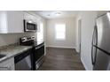 Bright kitchen with stainless steel appliances, granite countertops, and wood-look flooring at 4242 Timber Valley Ct, Decatur, GA 30032