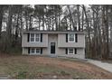 Charming two-story home with dark roof and black shutters nestled among trees at 1897 Madras Ct, Lithonia, GA 30058