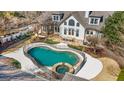Aerial view of a backyard featuring a pool with a safety fence, patio, and well-maintained landscaping at 610 Graystone Ct, Peachtree City, GA 30269