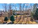 Landscaped front yard with mature trees framing a two-story home, a circular driveway, and inviting curb appeal at 610 Graystone Ct, Peachtree City, GA 30269