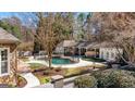 Backyard with a gated pool, spa, covered lounge, and meticulously landscaped garden offers luxury outdoor living at 610 Graystone Ct, Peachtree City, GA 30269