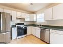 Well-lit kitchen with stainless steel fridge and dishwasher, gas range, and generous white cabinets at 2536 Lancewood Ln, Lithonia, GA 30058