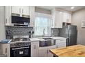 Bright kitchen with stainless appliances, white cabinets, and a farmhouse sink at 4657 Elam Church Rd, Forest Park, GA 30297